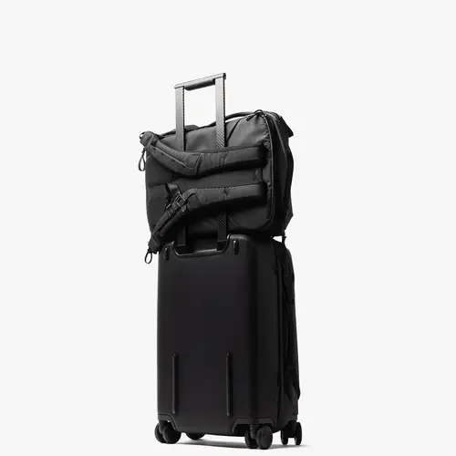 Black suitcase with a backpack attached on a white background