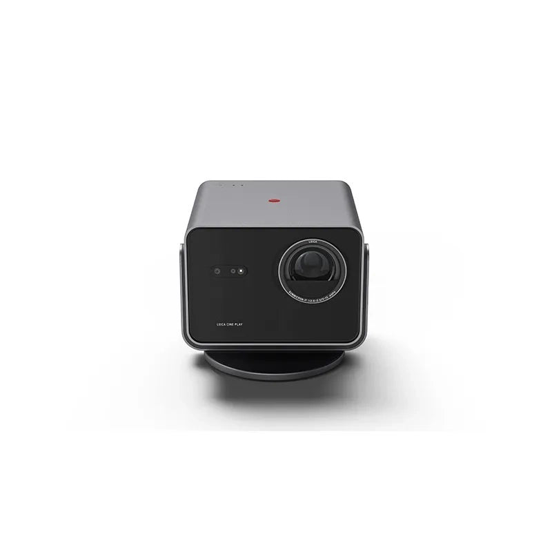 A black Leica Cine Play 1 mini projector with a sleek design, featuring a lens at the front and a power button with the Leica logo.